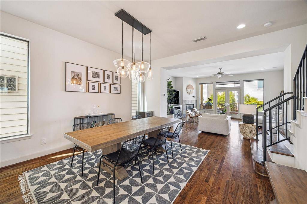 Perfectly situated between the kitchen and living room, the dining room features a newer decorative light fixture (installed in 2021) and ample space for a large dining table and additional furniture like a buffet. Expansive windows fill the room with natural light.