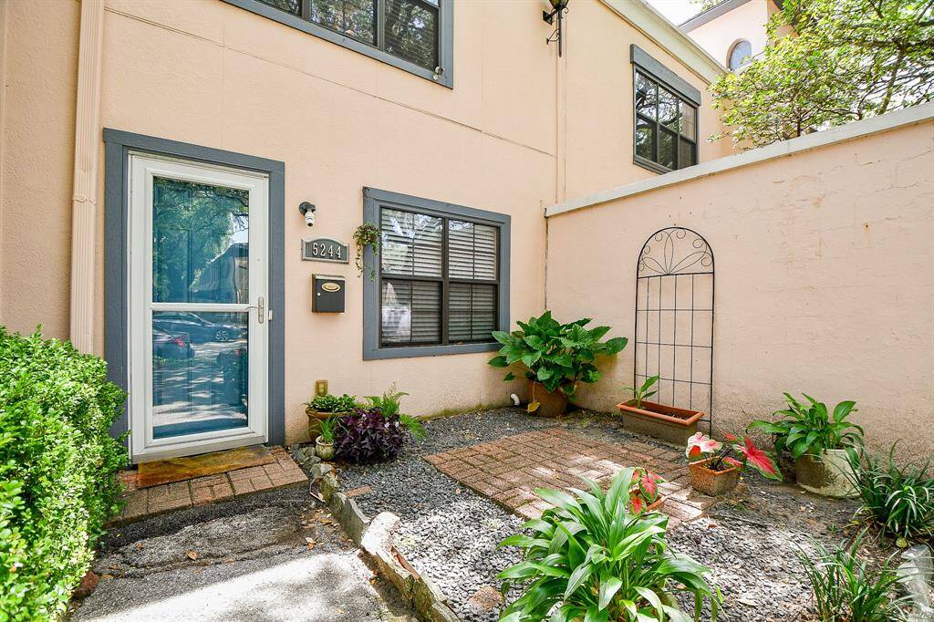 Welcome to this charming entryway with a glass door and cozy garden space.