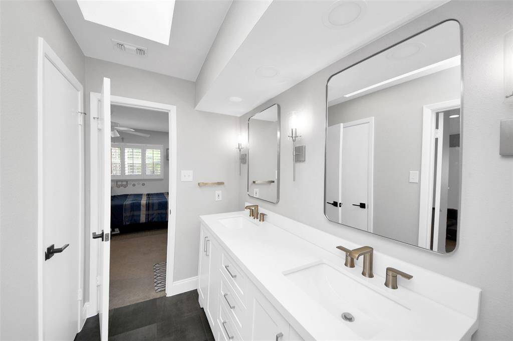 The fully updated Jack and Jill bathroom connects both secondary bedrooms featuring modern design, double vanity, and loads of storage.