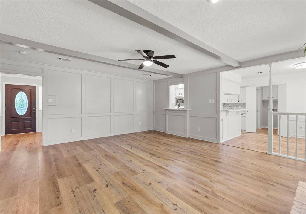 A view towards the entry from the family room. Ceiling fan, room open to breakfast room and kitchen.