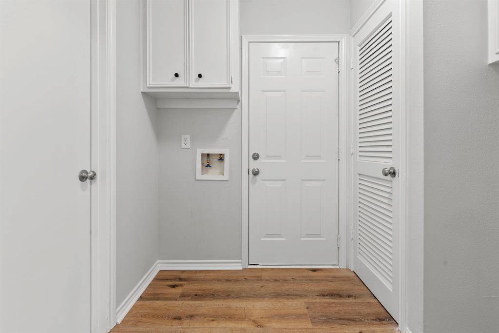 The laundry room, half bath on the left and attached garage access straight ahead. Again, fresh paint and those beautiful LVP floors!