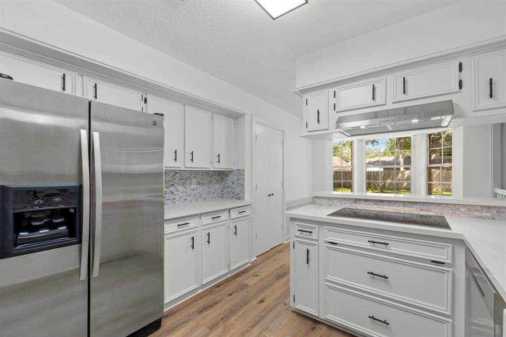 Stainless steel refrigerator/freezer, extra countertop and cabinets beyond the fridge. Entertaining will be a breeze!