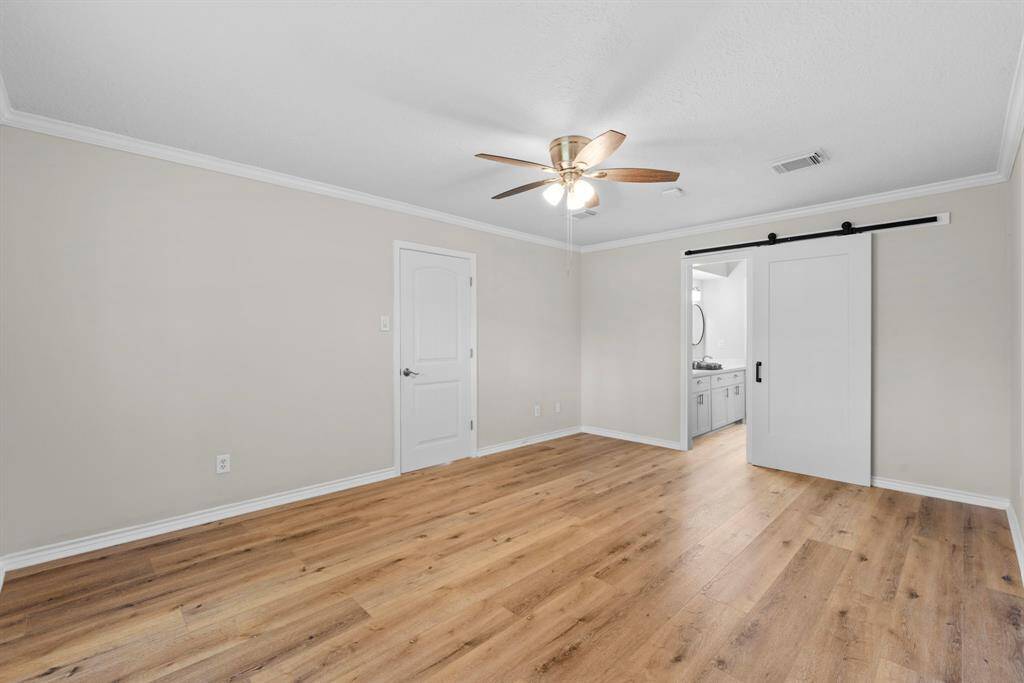This spacious primary bedroom has plenty of space for your largest bedroom suit! Look at the newly installed barn door that separates the bedroom from the updated primary ensuite bath!