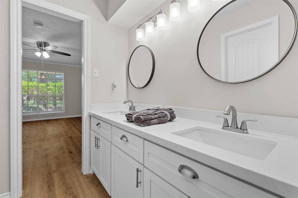 This fully updated primary bathroom has double sinks, white cabinets with updated hardware, updated mirrors and updated lighitng! Plenty of space for two to get ready in the mornings!