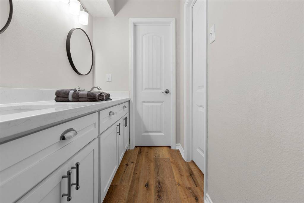 Another look at this vanity area. Notice the LVP flooring. The first door on the right is the tub/shower and toilet room, and the door straight ahead is to the large walk in closet.