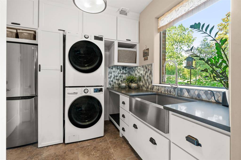 Such a pretty and practical laundry room!  Love the big window offering plenty of sunshine!  And, look at the size of this sink!