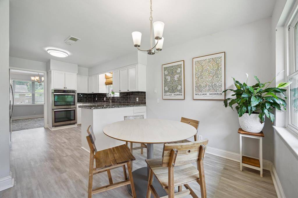 From the breakfast room, looking into the kitchen with double ovens and abundant cabinetry.