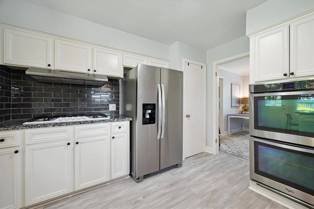The 5 spot gas cooktop and overhead vent, subway tile backsplash,refrigerator freezer, pantry and double ovens.