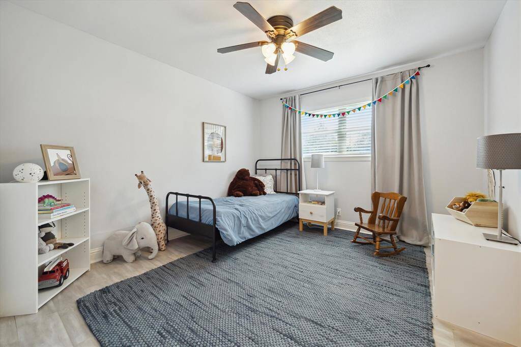 A secondary bedroom with ceiling fan and window to Braesmont.
