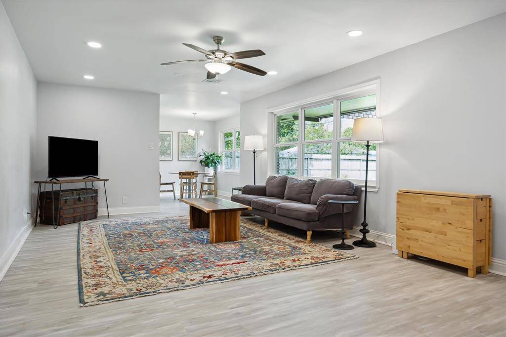 The spacious den with triple window view to the patio and back yard, recessed can lighting and ceiling fan.