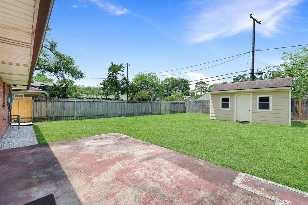 Expansive backyard with a lush lawn and fully powered shed—perfect for outdoor fun and extra storage.