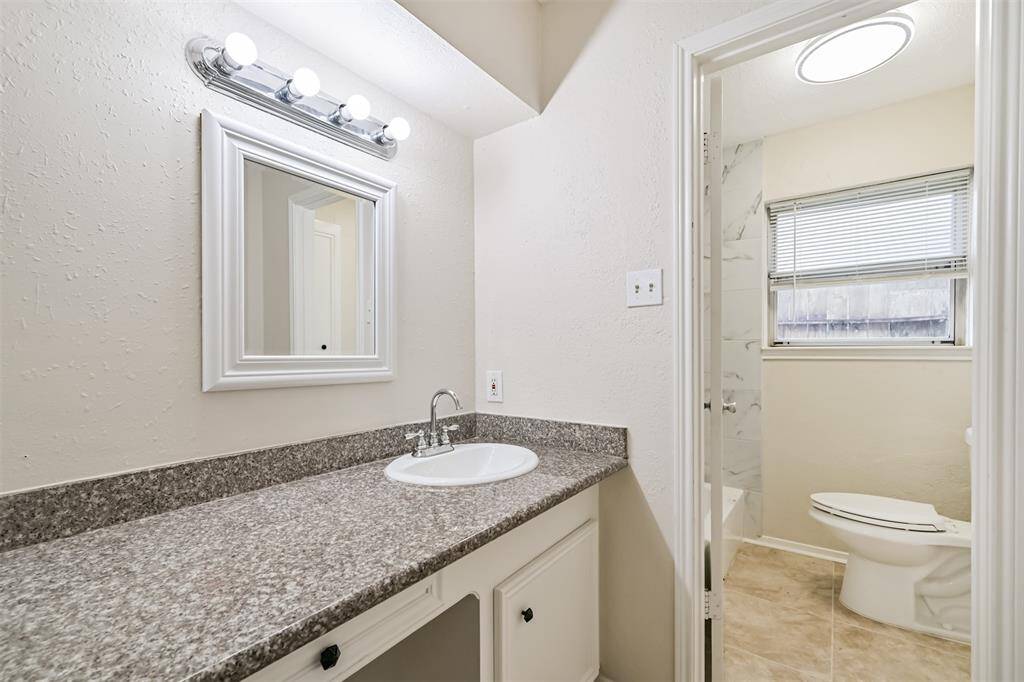Primary bath has separate vanity area with dual sinks and granite countertop