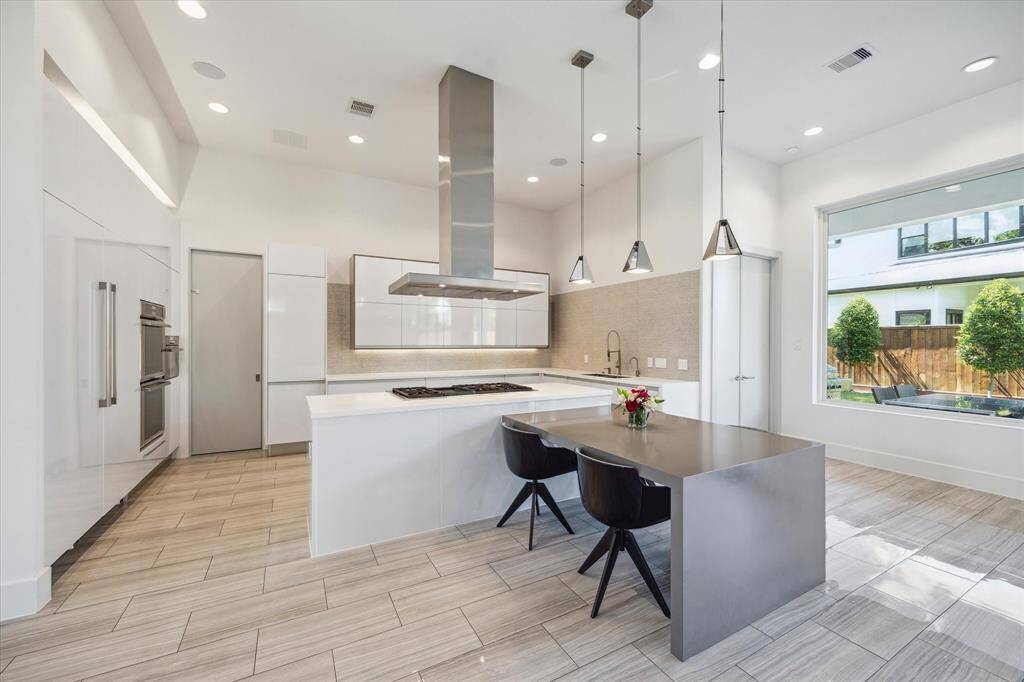 This stunning chef's kitchen offers krion countertops with a custom breakfast bar.