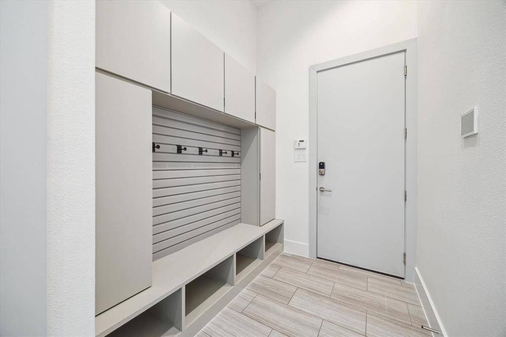 The mudroom offers built-in cabinetry for concealed storage and a seamless transition from the garage.