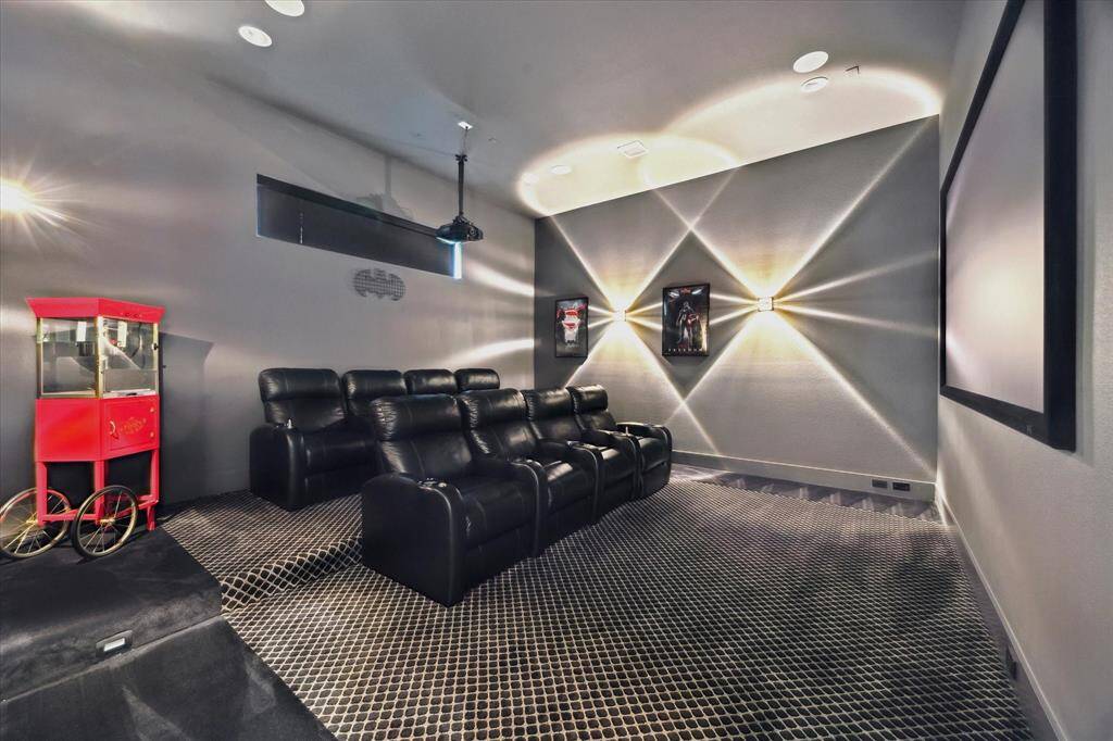 Step into this state-of-the-art media room, outfitted with mood lighting, dark walls, carpeted flooring perfect for movie nights.