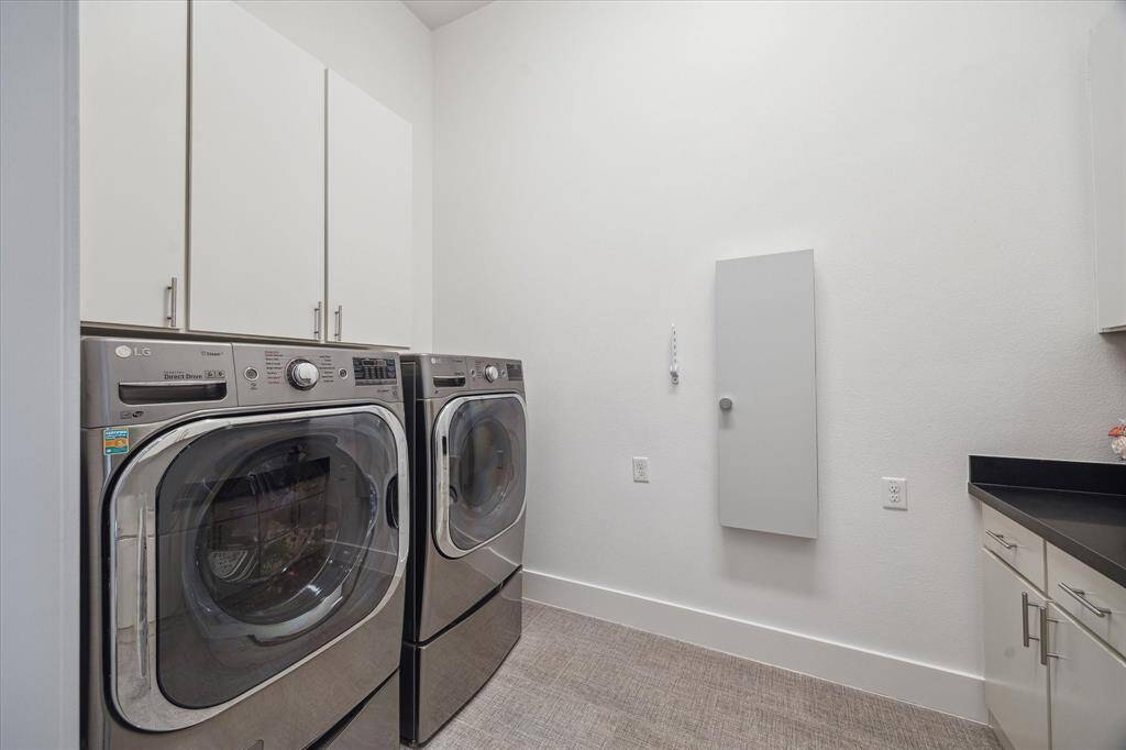 This stylish and functional laundry/utility room features custom cabinetry, built-in sink, and a countertop great for folding clothes.