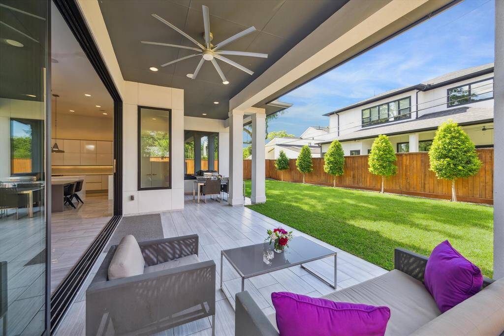 Expansive covered patio with tiled flooring and large ceiling fan provides the perfect space for outdoor entertaining, dining, or relaxing in the shade, rain or shine.