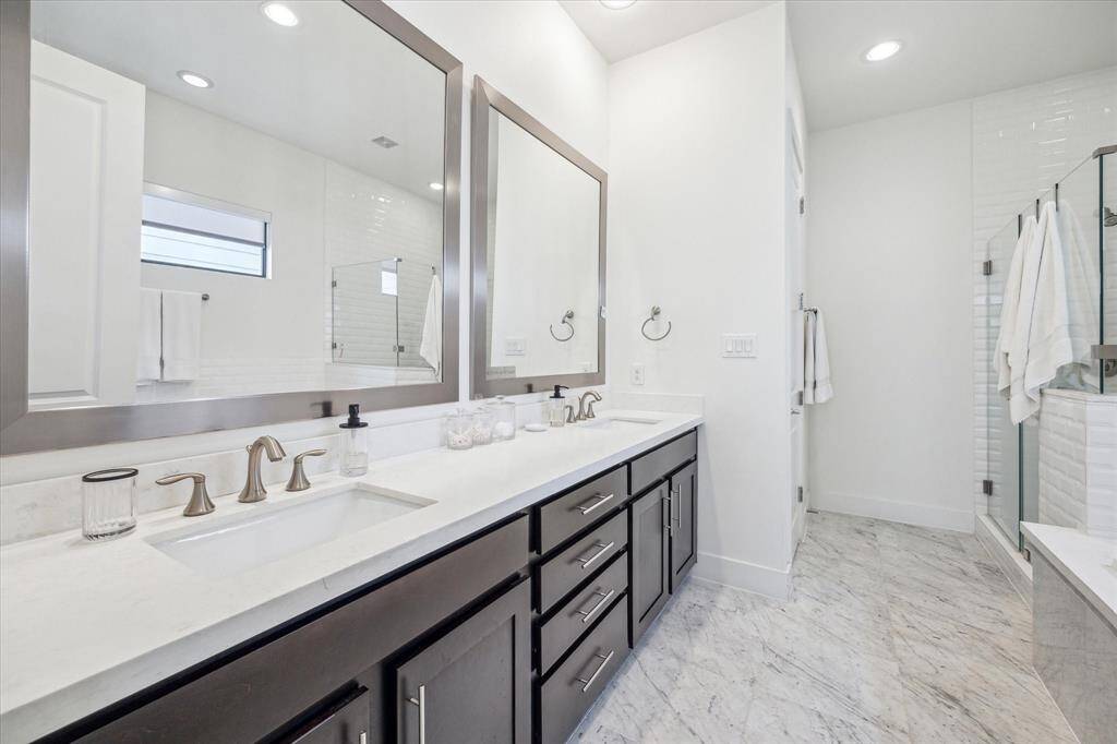 The primary bath boasts his and hers sinks as well as a full shower and bathtub.