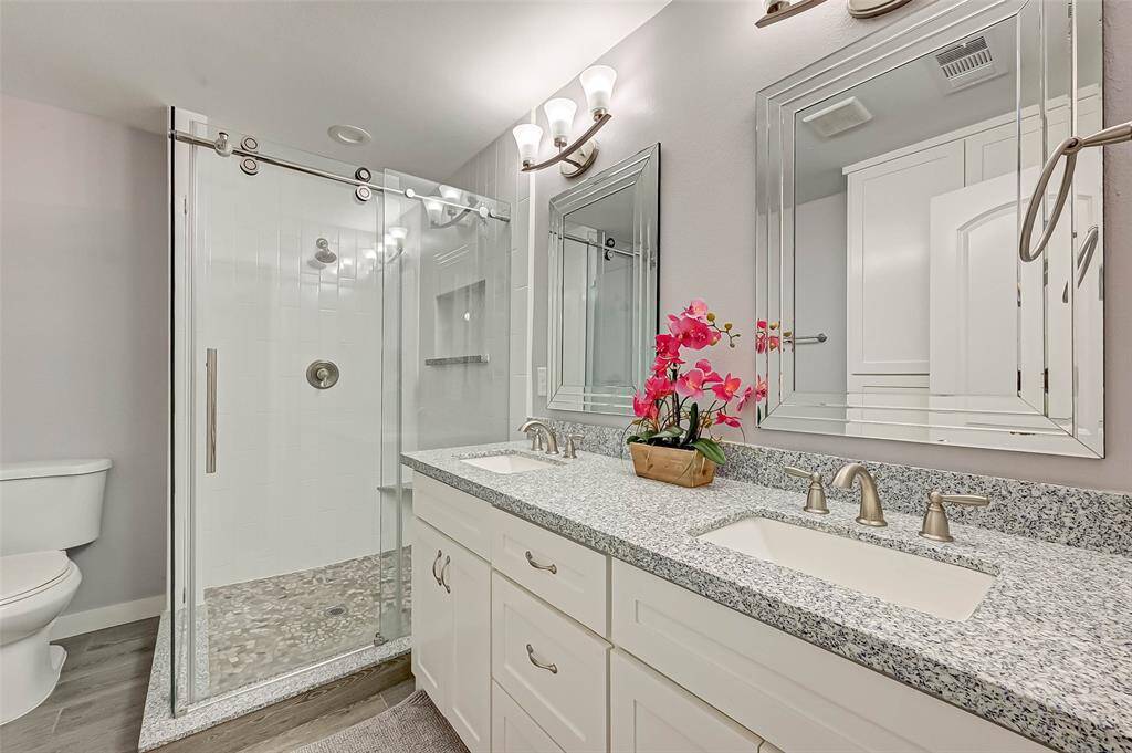 This Primary Suite bathroom has dual sinks and large stand up shower with plenty of storage.  Update with granite counter tops.