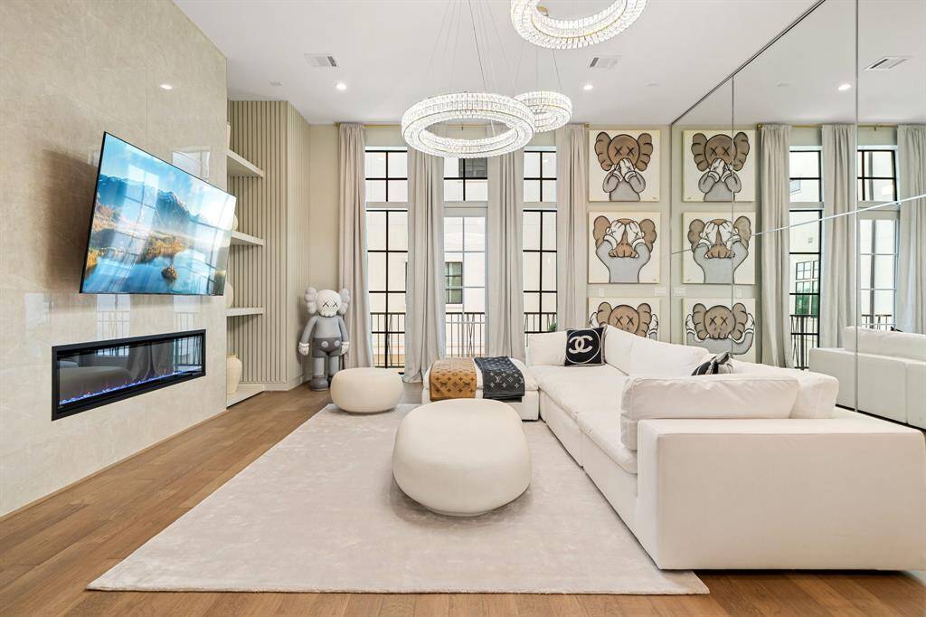 Large sectional sofa, contemporary art. and wall-mounted above a sleek fireplace ALL STAYS!