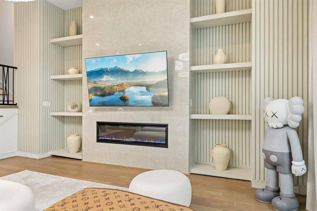 Mounted TV, flanked by stylish shelves with decorative vases! A playful sculpture adds a touch of whimsy, while the neutral tones create an inviting atmosphere!