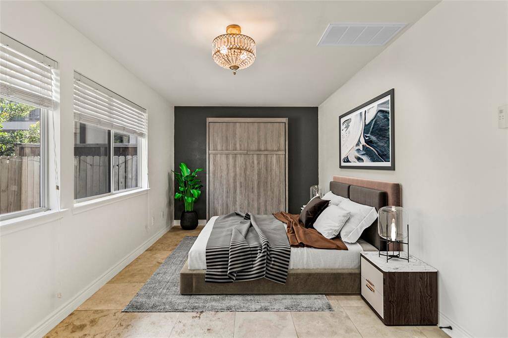 Natural light pours into this versatile ground floor space, making it perfect for a home office, guest room, or creative studio. The neutral tile flooring, crisp white walls, and elegant black accent wall provide a clean, modern backdrop—while the built-in Murphy bed adds a smart space-saving feature for ultimate flexibility.