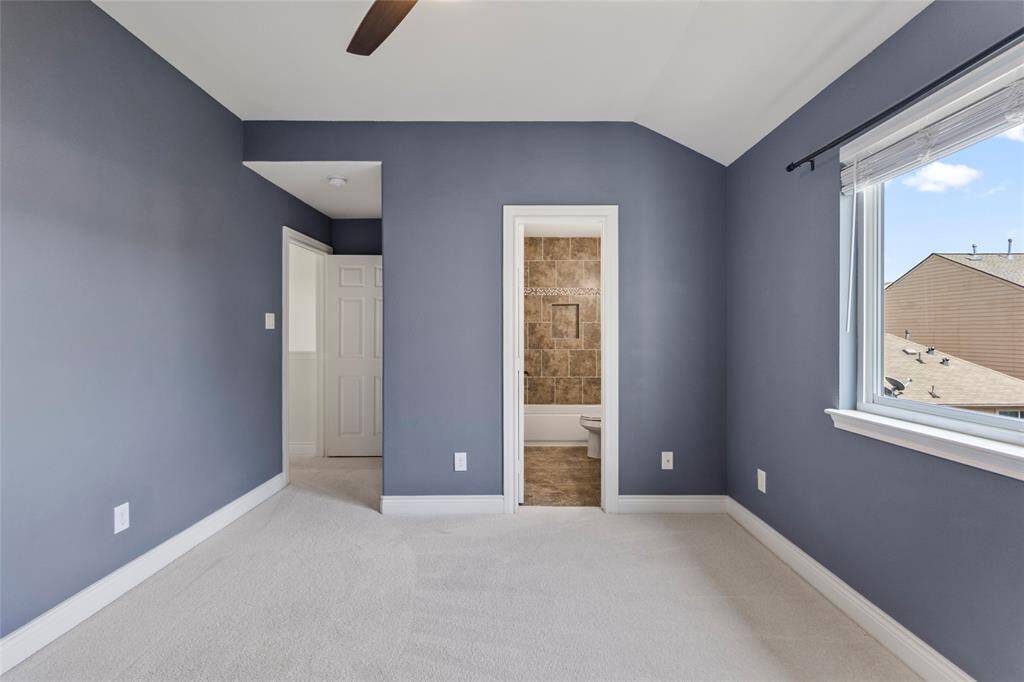 Here is your secondary bedroom without virtual staging. Natural light fills the room, highlighting the soft carpet and calming wall color that create a serene, inviting atmosphere. With an en-suite bath and a view that opens up to the outside, this space easily transforms into your own private haven.