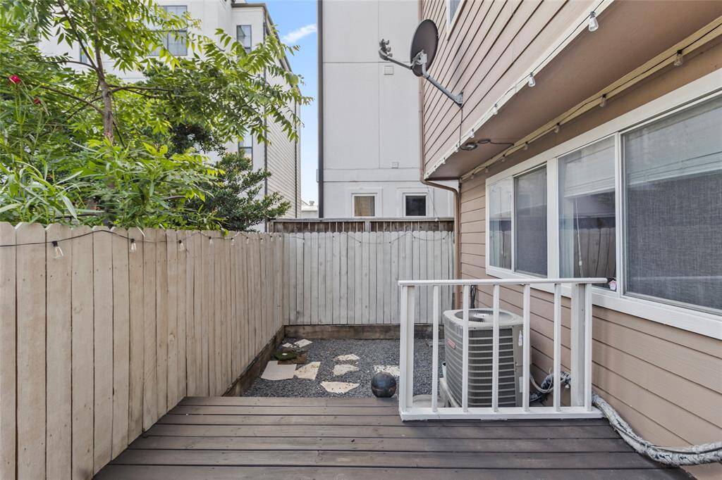 A cozy extension of your home, the backyard features a compact raised deck and a gravel-lined side yard with paver stones—perfect for a container garden, pets, or a little fresh air escape. String lights overhead add a warm, inviting glow to your own quiet corner of the city.