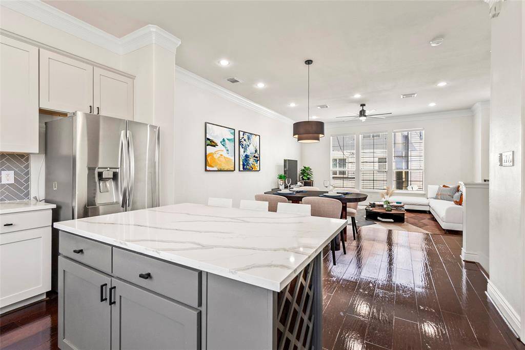 Wide open and filled with natural light, your combined kitchen, dining, and living space creates a seamless flow for everyday living or weekend hosting. Rich wood floors, crown molding, and recessed lighting add a polished feel, while the oversized island anchors the heart of the home with both function and style.