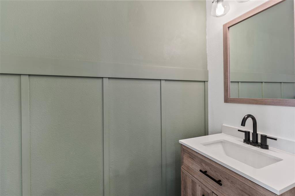 Located on the 2nd floor is your half bath. Featuring warm wood tones, a matte black faucet, and stylish sage-green wall. It's a simple, polished space that makes a lasting impression on guests.