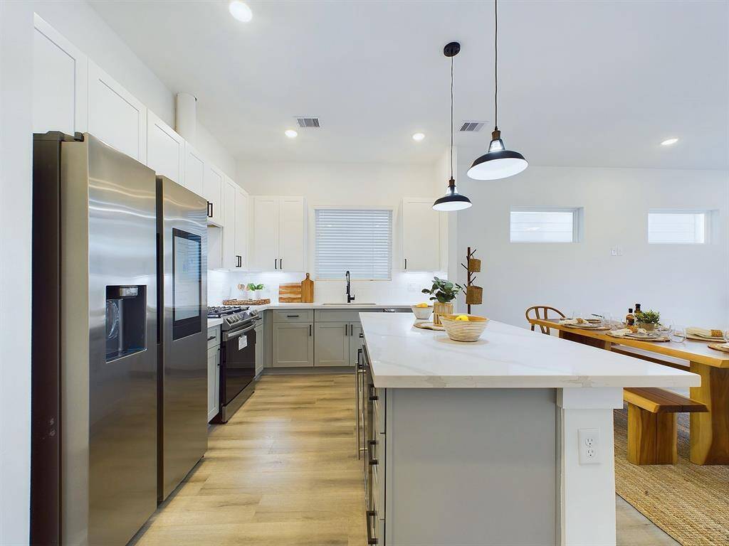The kitchen offers  quartz countertops, stainless steel appliances, recessed lighting, and shaker cabinets and hardware with under cabinet lighting.