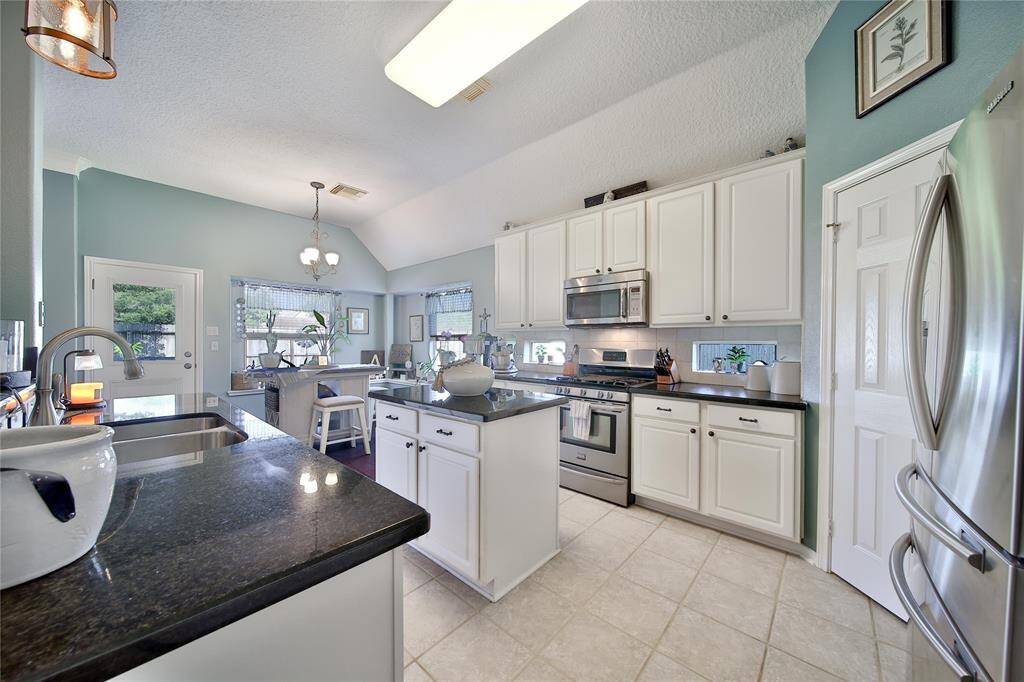 Granite countertops grace this kitchen that is full of natural light, updated appliances and has a walk-in pantry!