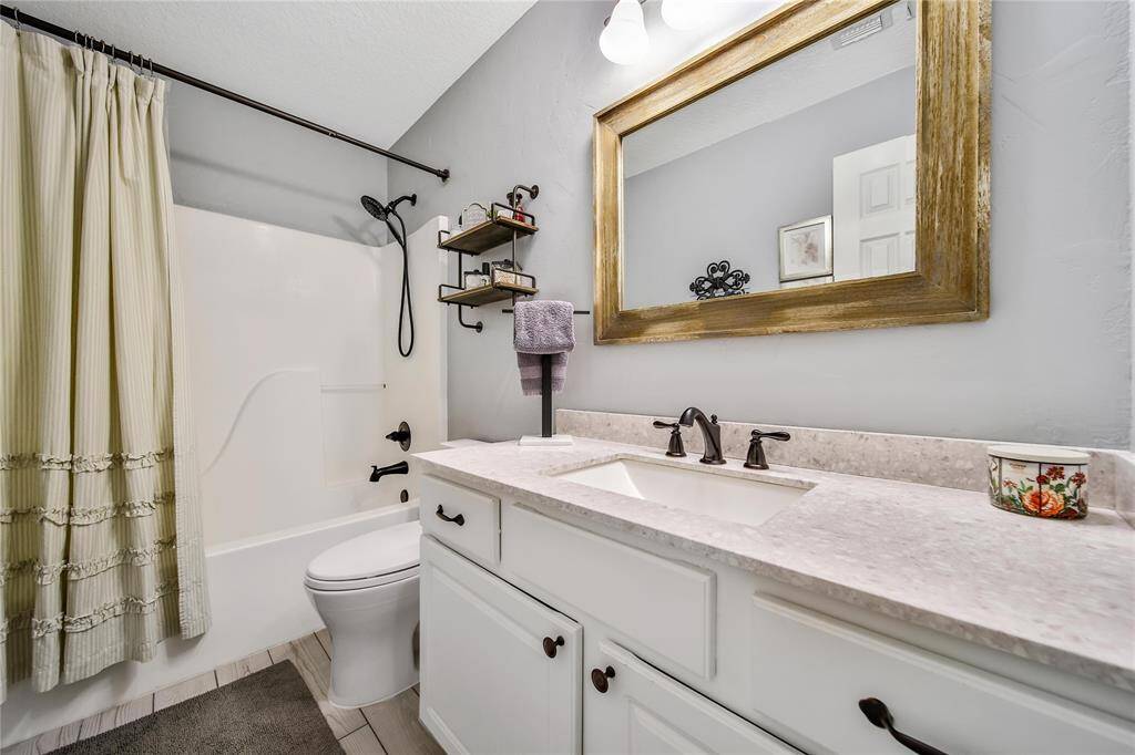 Bathroom 2 located down the hallway serves 3 secondary bedrooms.  Featuring updated fixtures, mirror and vanity!