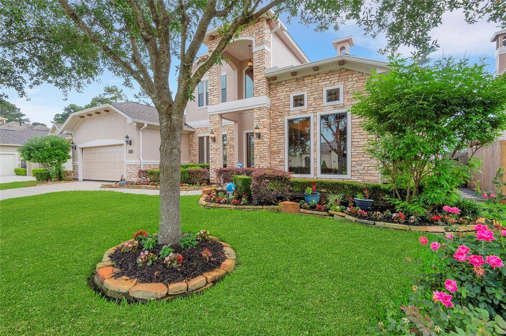 Welcome to 6119 Lofty Lane! The front yard features lush grass, colorful flowerbeds, and a mature oak tree, contributing to the home's inviting curb appeal. The large windows allow for an abundance of natural light .
