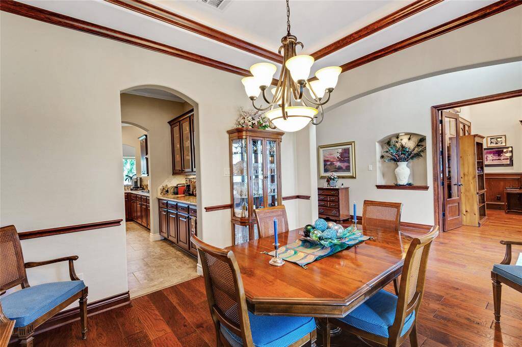 The dining room's architecture offers multiple arches and tray ceiling.