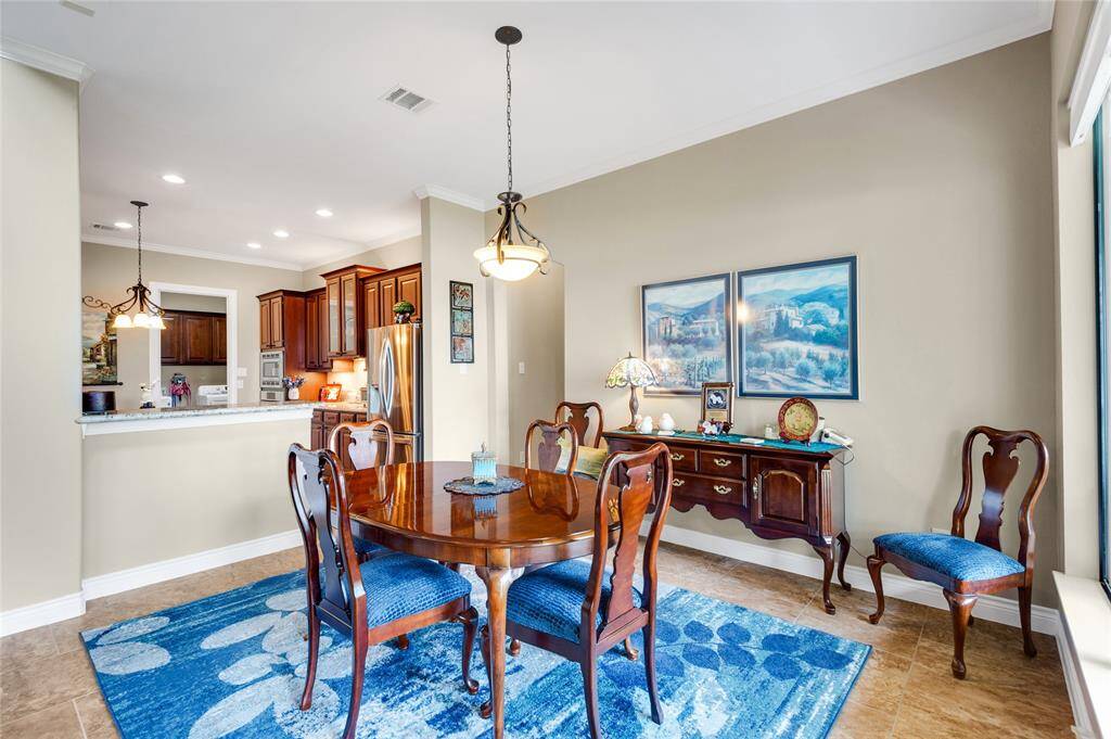 The sizeable breakfast  area is open to the family room and kitchen. The adjacent kitchen has stainless steel appliances and rich wood cabinetry, creating a seamless flow for entertaining.