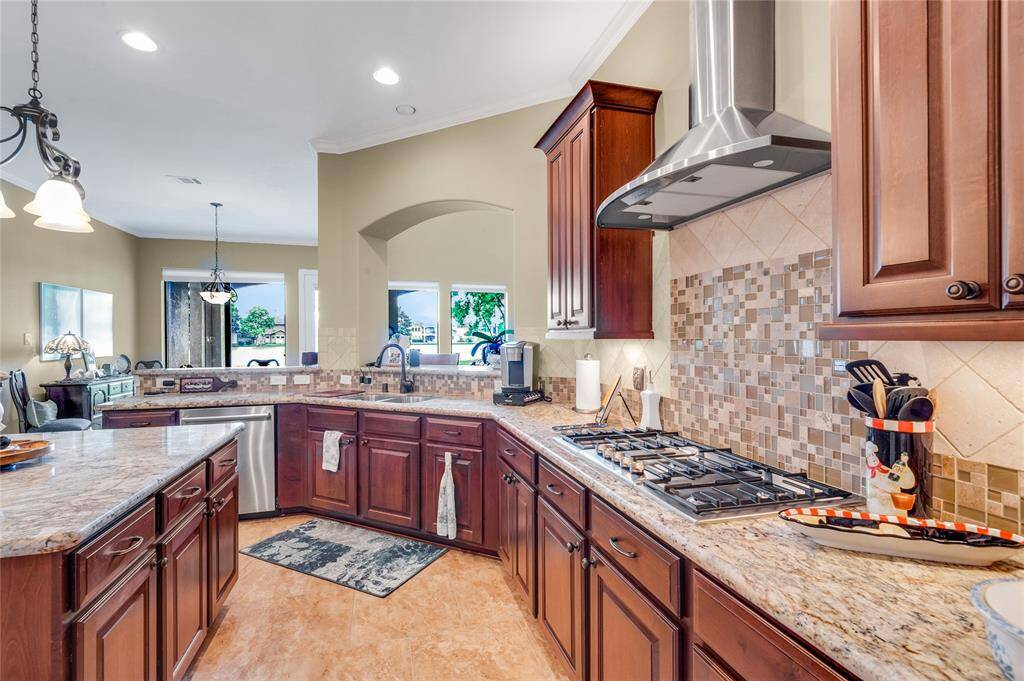 This kitchen features raised panel cabinet doors, granite countertops, a modern tile backsplash, and stainless steel appliances. Soft close drawers and doors.