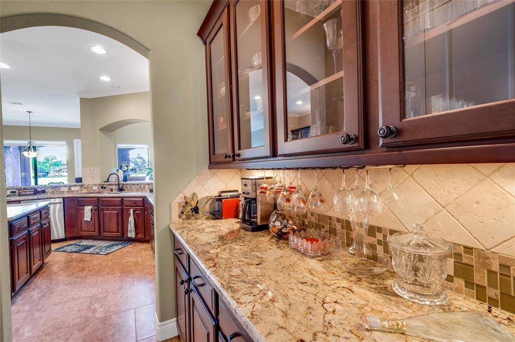 The  butler's pantry feature glass-front cabinets and granite countertop.