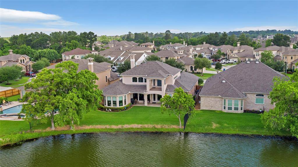 This home offers a breathtaking lakefront view, surrounded by lush mature landscaping. The setting offers a well-maintained neighborhood with similar upscale homes, providing a serene and inviting environment.