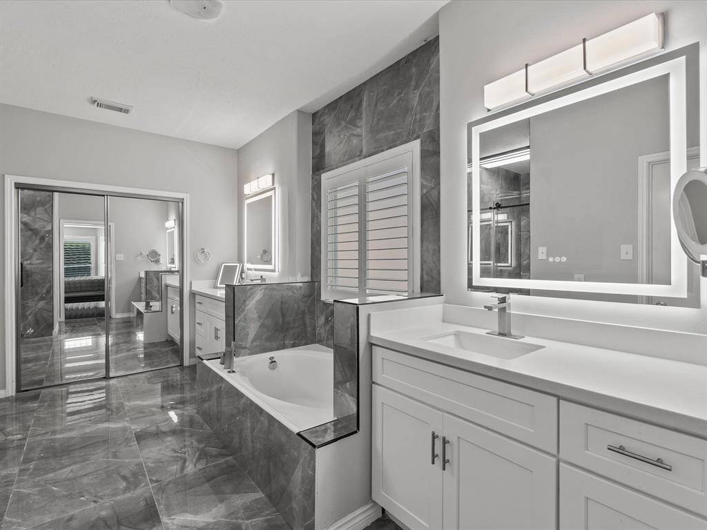 Primary ensuite bath with double walk in closets and soaking tub