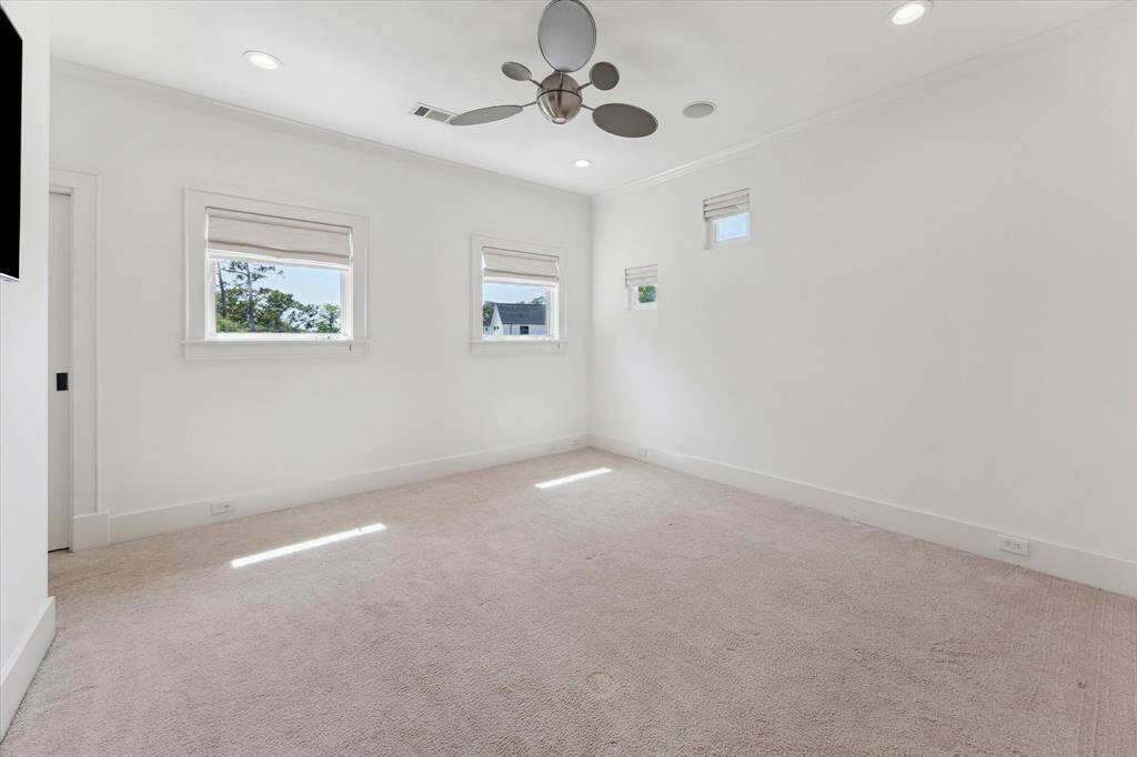Versatile fourth bedroom or library featuring a wet bar, custom built-ins, and access to a private balcony.