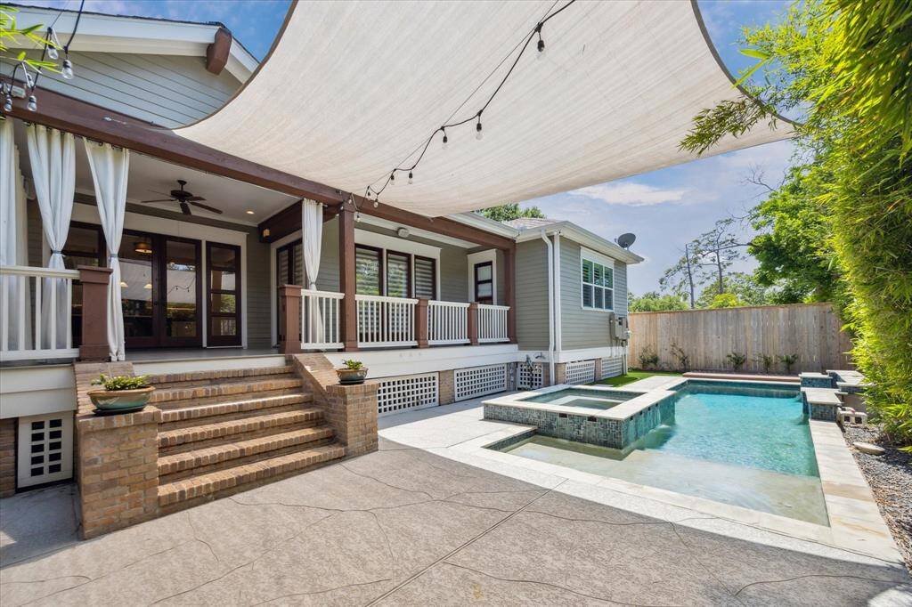 Sweeping view of the sparkling pool from across the landscaped backyard.