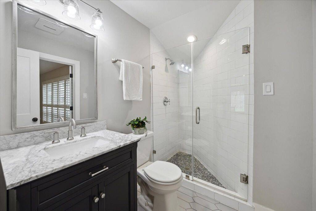 The secondary bathroom is thoughtfully situated with access from both the front bedroom and the foyer, offering flexibility for guests.