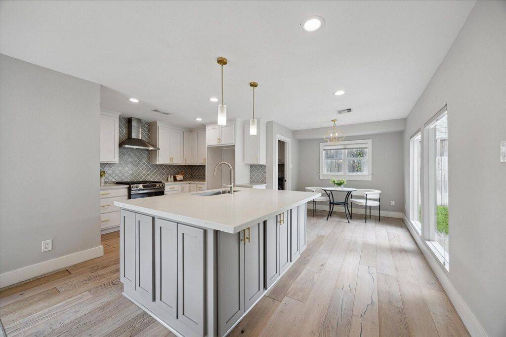 Anchored by a quartz-topped island with built-in storage, the kitchen pairs clean design with everyday functionality and stainless steel finishes.