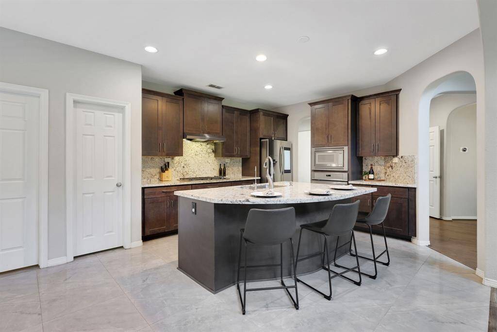 Large kitchen island offers additional seating and farm style sink