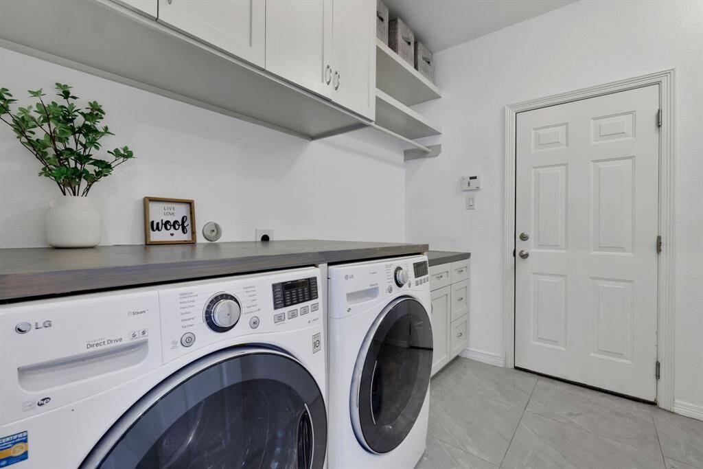 Utility room featuring custom cabinets for additional storage and garage access