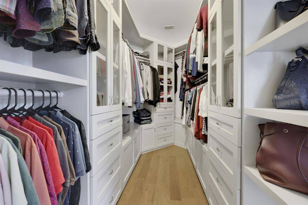 Beautifully updated primary walk-in closet with recent custom built ins complete with shelves, drawers and cabinets!