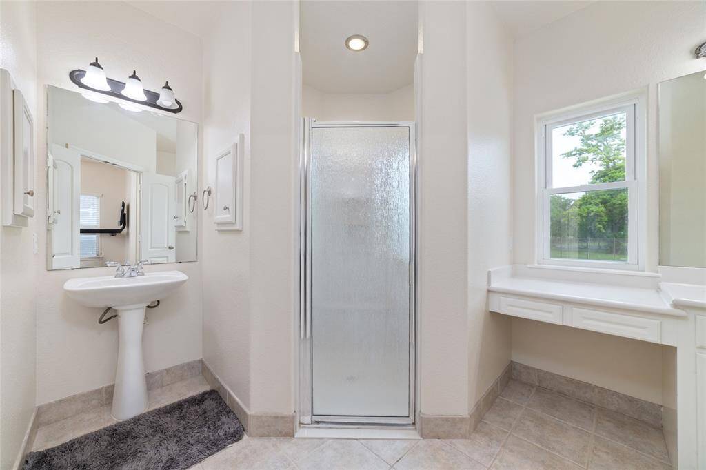 Primary bathroom with double closets, double sinks, and an oversized shower.