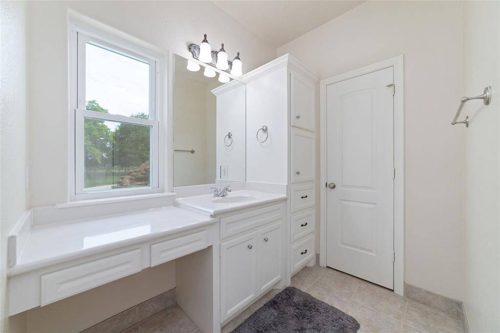 Primary bathroom with double closets, double sinks, and an oversized shower.