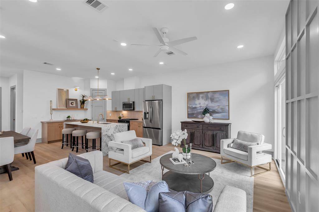 A corner view of the living room highlights the open layout connecting the living area, kitchen, and dining space.